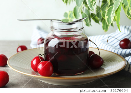 Cherry jam and ingredients on gray textured table 86176694