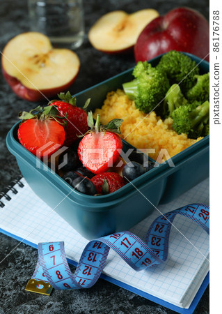 Diet concept with lunch box on black smokey table Diet concept with lunch box on black smokey table 86176788