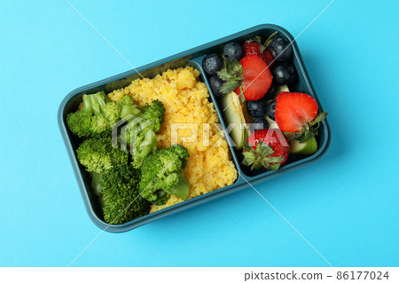 Lunch box with tasty food on blue background 86177024