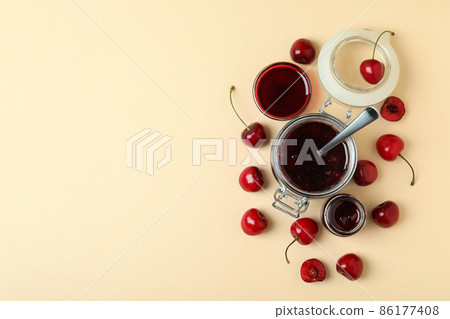 Cherry jam and ingredients on beige background Cherry jam and ingredients on beige background 86177408