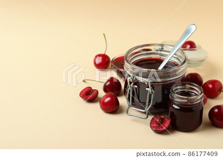 Cherry jam and ingredients on beige background Cherry jam and ingredients on beige background 86177409