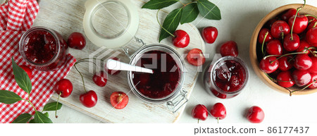 Cherry jam and ingredients on white textured table 86177437