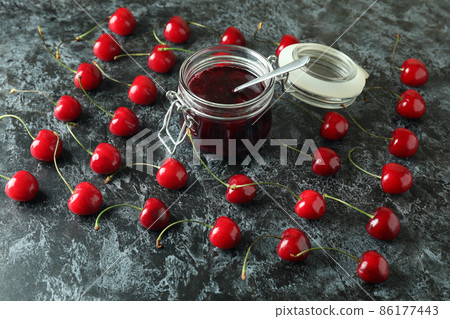 Cherry jam and ingredients on black smokey background Cherry jam and ingredients on black smokey background 86177443