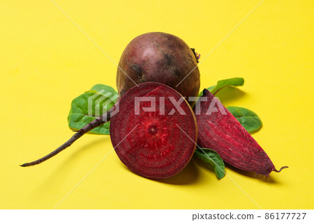 Ripe red beet with leaves on yellow background 86177727