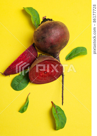 Ripe red beet with leaves on yellow background 86177728