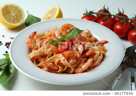 Plate of shrimp pasta and ingredients on white background 86177939