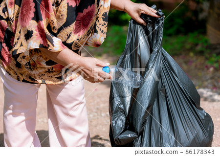 Senior woman picking up plastic bottle 86178343