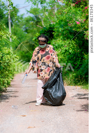 Senior woman picking up plastic bottle 86178345