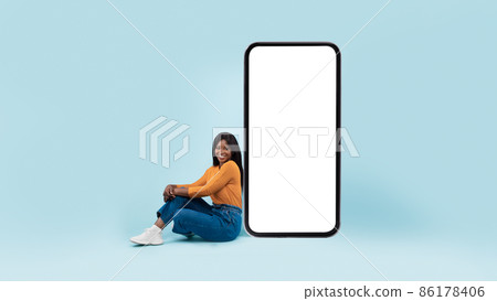 Black lady presenting big white empty smartphone screen 86178406