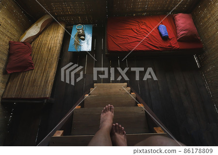 Person looking down at a dark empty wooden cabin room Person looking down at a dark empty wooden cabin room 86178809