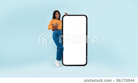 Black lady presenting big white empty smartphone screen Black lady presenting big white empty smartphone screen 86178844