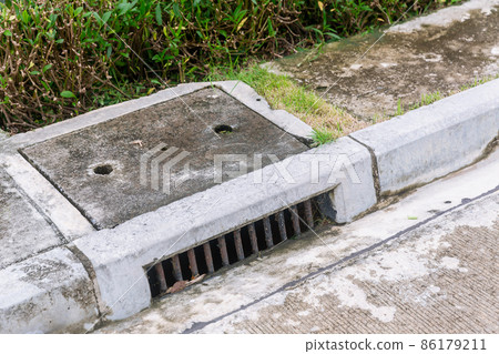 Sewer Drain along Road. Sewer Drain along Road. 86179211