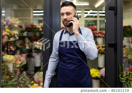 florist businessman talking on the phone next to the refrigerator with flowers florist businessman talking on the phone next to the refrigerator with flowers 86181219