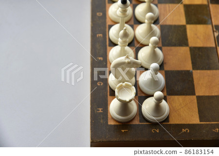 An old chessboard with white and black pieces 86183154