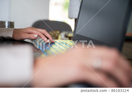Female hands using computer mouse and typing on laptop Female hands using computer mouse and typing on laptop 86183224
