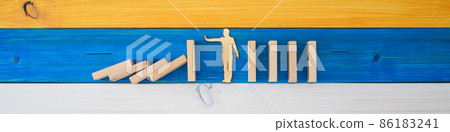 Wide view image of paper cut silhouette of a man stopping dominos Wide view image of paper cut silhouette of a man stopping dominos 86183241