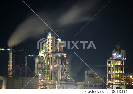 Illuminated cement plant with high factory structure and tower cranes at industrial production area at night. Manufacture and global industry concept Illuminated cement plant with high factory structure and tower cranes at industrial production area at night. Manufacture and global industry concept 86183341