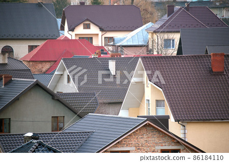 Residential houses with roof tops covered with metallic and ceramic shingles in rural suburban area 86184110