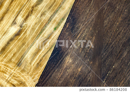 Aerial view of plowed agricultural field prepared for planting crops in spring Aerial view of plowed agricultural field prepared for planting crops in spring 86184208