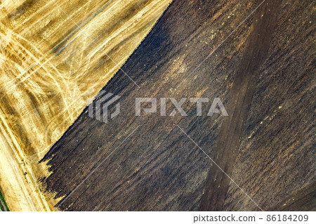 Aerial view of plowed agricultural field prepared for planting crops in spring 86184209