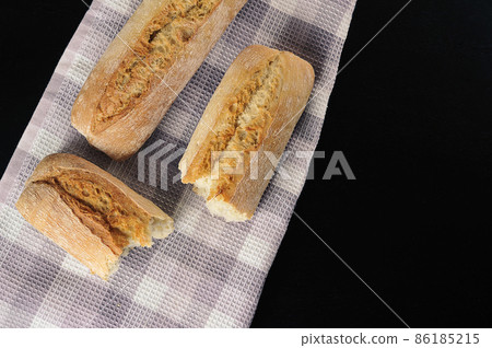 mini baguettes on a black background - French cuisine mini baguettes on a black background - French cuisine 86185215