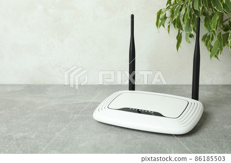Wi-Fi router and plant on gray textured table 86185503