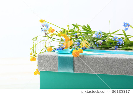 wild flowers on gift box on white wooden background wild flowers on gift box on white wooden background 86185517