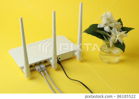 Wi-Fi router and flowers on yellow background 86185522