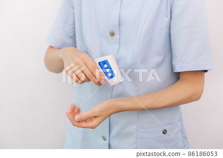 Temperature measurement gun in doctor hands. Close-up shot of doctor wearing protective surgical mask ready to use infrared isometric thermometer gun to check body temperature for virus symptoms. Temperature measurement gun in doctor hands. Close-up shot of doctor wearing protective surgical mask ready to use infrared isometric thermometer gun to check body temperature for virus symptoms. 86186053