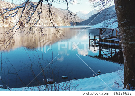 Mountain lake in winter, pier house under snow 86186632