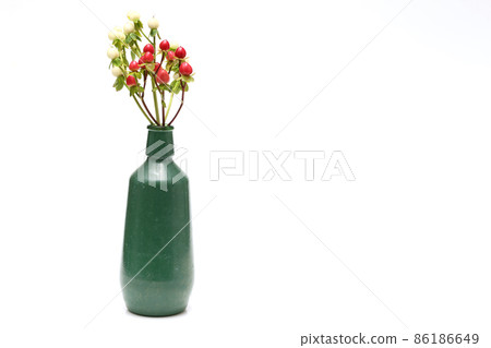 Hypericum fruit in a green bottle with a white background 86186649