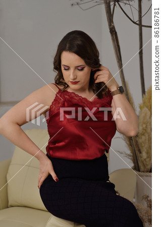 A beautiful young girl posing in a light armchair. A beautiful young girl posing in a light armchair. 86186781