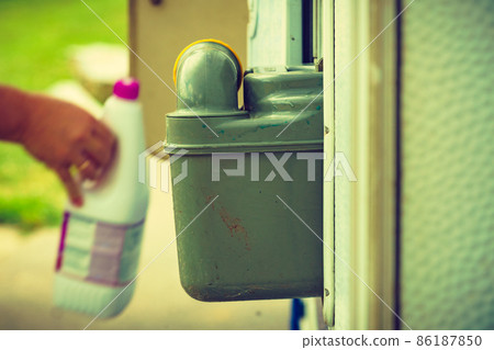 Man serving caravan, tank toilet cassette in dump station. 86187850