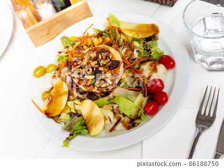Tasty salad with goat cheese, nuts and apples.  86188750