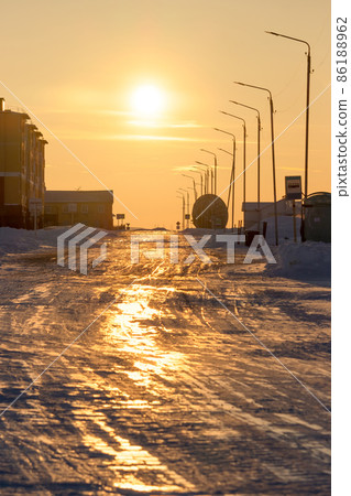 View of the street and buildings of a small arctic village at sunset View of the street and buildings of a small arctic village at sunset 86188962