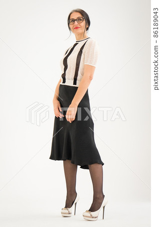 Studio photo of middle aged woman starting getting grey-haired wearing black and white clothes on white background, middle age sexy lady, happy life concept 86189043