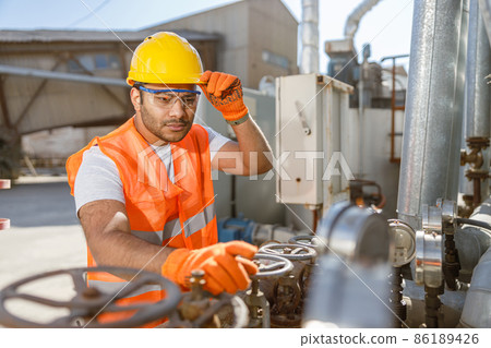 Worker with safety equipment working at construction plant 86189426