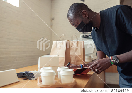 Black man working deliveryman in covid-19 pandemic Black man working deliveryman in covid-19 pandemic 86189469