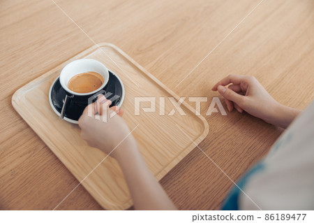 Female hand holding black cup of coffee Female hand holding black cup of coffee 86189477