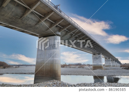 The pier of the bridge over the river looking up from below 86190385