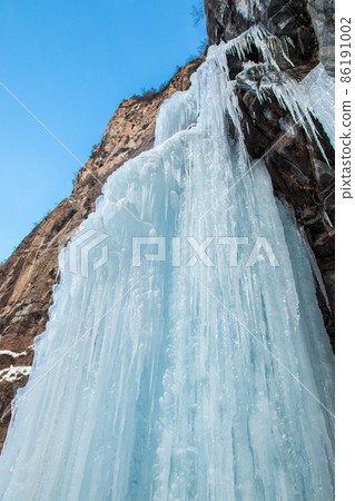 Frozen waterfall on rocky mountain in winter day in Almaty region Frozen waterfall on rocky mountain in winter day in Almaty region 86191002
