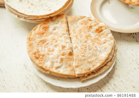 flatbread with potatoes, On a white wooden table. Traditional Muslim dish flatbread with potatoes, On a white wooden table. Traditional Muslim dish 86191488