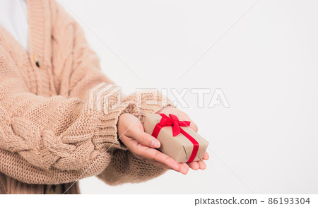 Woman beauty hands holding small gift package box present Woman beauty hands holding small gift package box present 86193304
