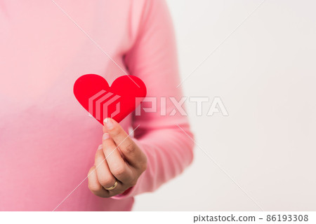 Woman beauty hands holding red heart for giving Woman beauty hands holding red heart for giving 86193308