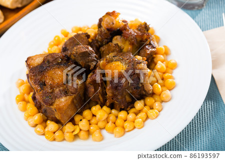 Braised oxtails with chickpeas on a white plate Braised oxtails with chickpeas on a white plate 86193597