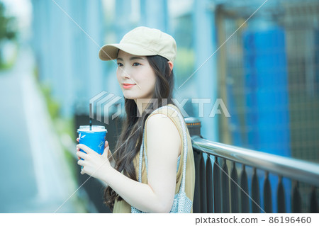 Women walking while drinking iced coffee Women walking while drinking iced coffee 86196460