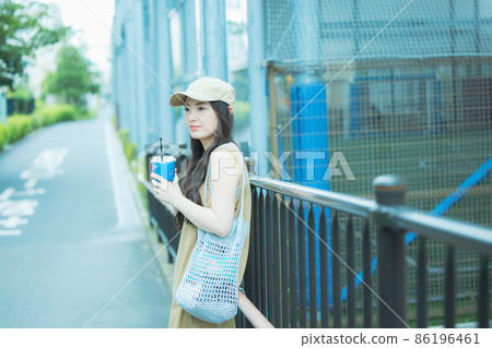 Women walking while drinking iced coffee Women walking while drinking iced coffee 86196461