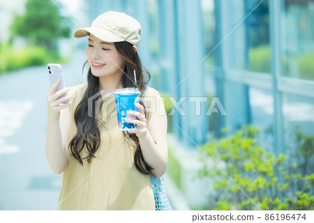 A woman watching a smartphone A woman watching a smartphone 86196474