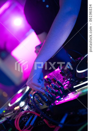 Dj mixing at party festival with light and smoke in background - Summer nightlife view of disco club Dj mixing at party festival with light and smoke in background - Summer nightlife view of disco club 86196834
