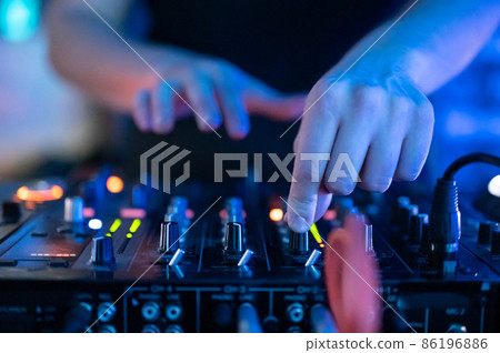 Close up Front view of of DJ hands controlling a music table in a night club. 86196886